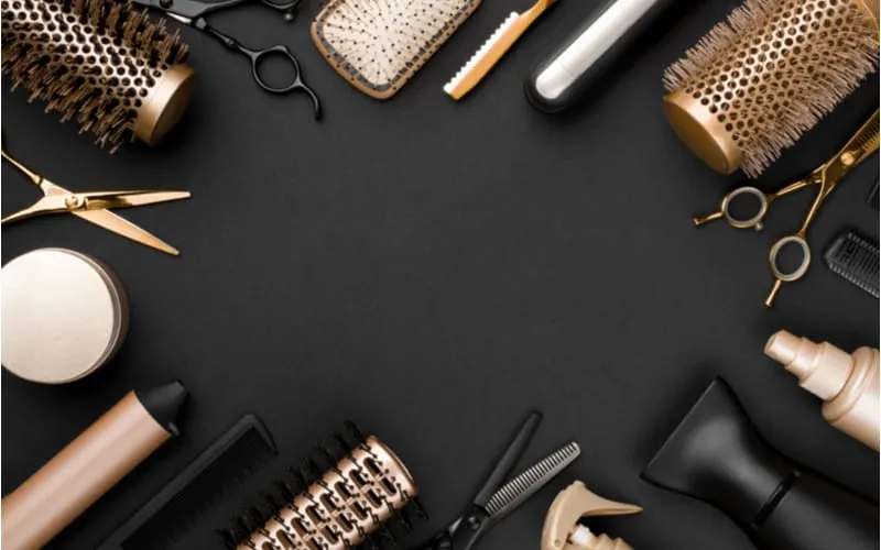 Hairdresser tools on black background with copy space in center