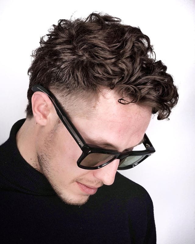Mens Haircut 7 with a guy in sunglasses and a slight beard with a soft curls hairstyle