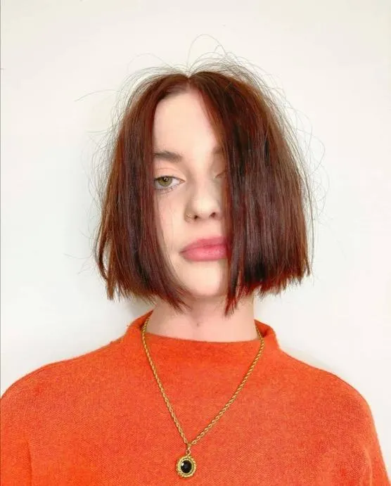 Frizzy bob haircut worn by a woman in a red sweater