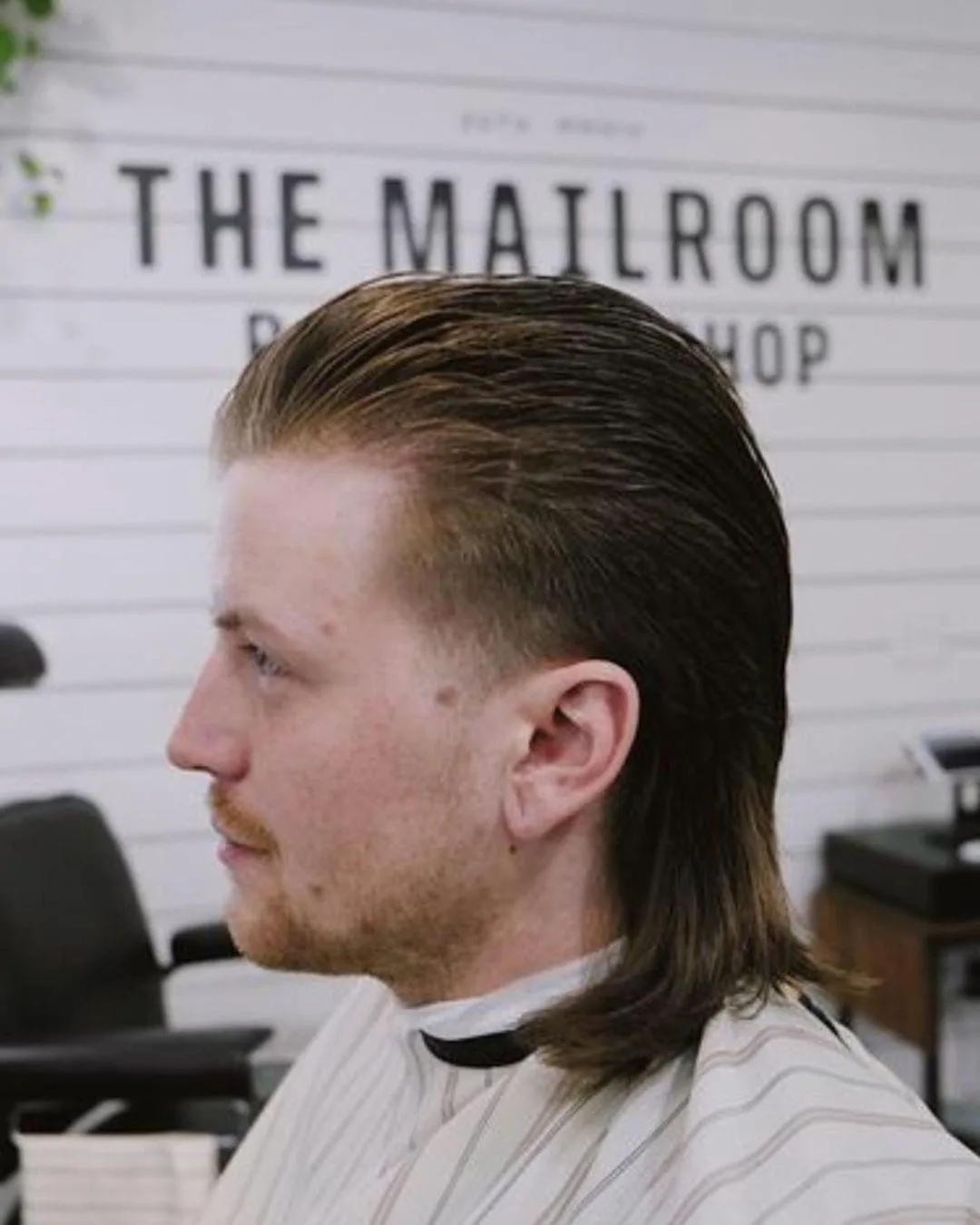 Man with a faded mullet sits in the barber chair