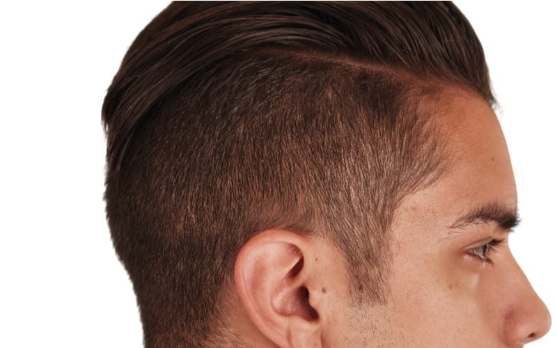 Close up Side view of Hispanic man with cool undercut standing with white background