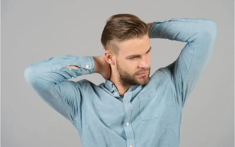 Macho in blue fashionable shirt, fashion. Man with bearded face and blond hair, haircut. Mens fashion style and trend. Grooming and hair care in beauty salon, barbershop