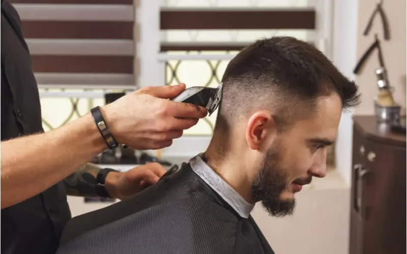 A guy getting a high fade haircut from a barber