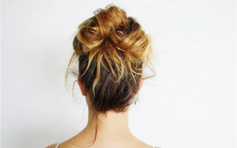 Woman with dyed hair in a messy bun for a piece on unprofessional hairstyles