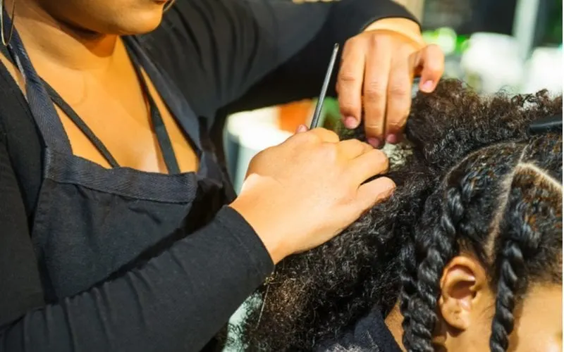 To answer the question how long does your hair need to be to braid, a young woman sits in a salon chair