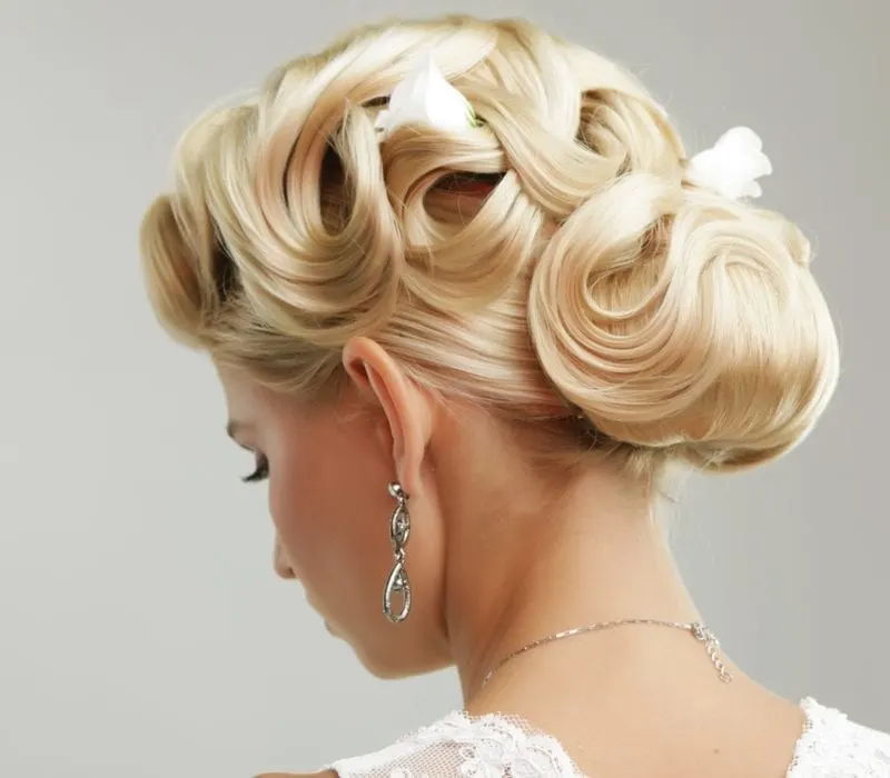 Person wearing a wedding dress with a bunch of barettes in her hair