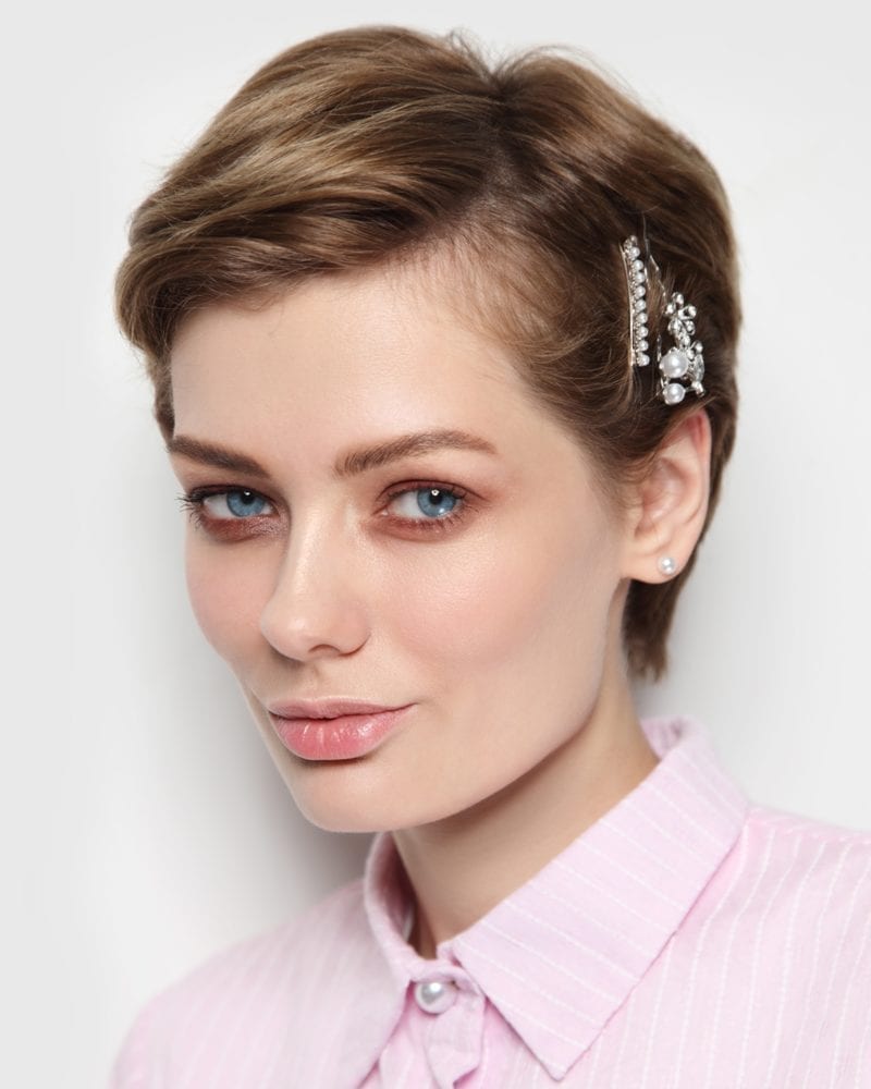 Vintage style portrait of young beautiful woman with fancy hairpins in her hair