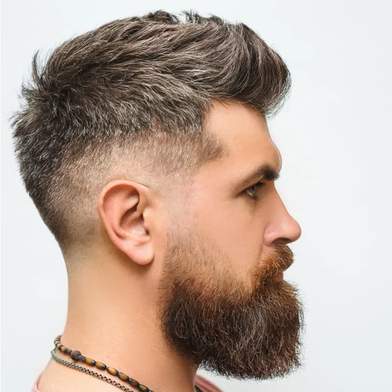 High fade haircut on a rugged looking man wearing a necklace