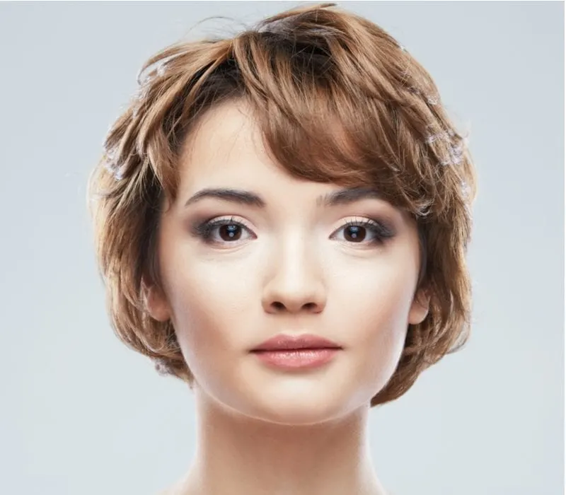 Young woman with a short shag haircut close up face beauty portrait.Short Hair style. Female model isolated white background.