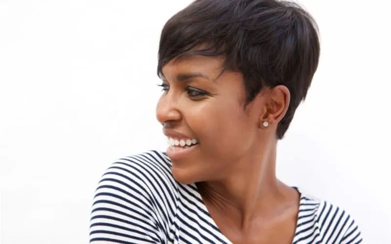 Close up portrait of a young african american woman with a short haircut smiling and looking away