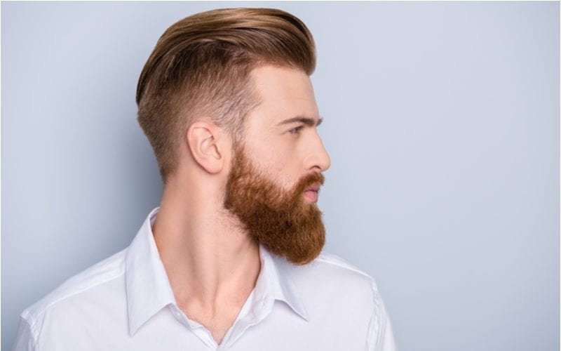 A hairstyle for balding men, Side view portrait of confident bearded man with beautiful hairstyle in white shirt looking on copy space