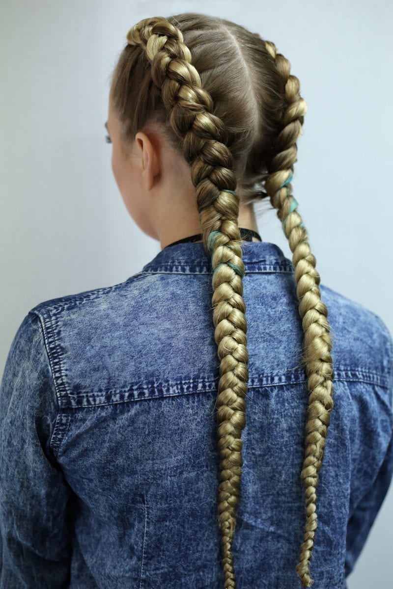 As an image for a piece on unprofessional hairstyles, braids on a woman in a blue jean jacket