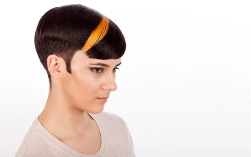 Young girl with highlighted bicolor masculine pixie short haircut. Horizontal studio portrait with negative space. White background.