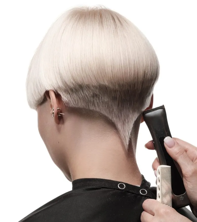 Unique version of an undercut and rat tail bowl cut being shaved into a woman's head