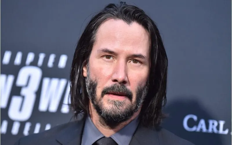 Image of Keanu Reeves with a widows peak and long hair at the premier of John Wick 3