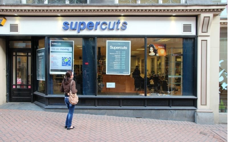 As an image for a piece on Supercuts hours, a person stands outside a store location