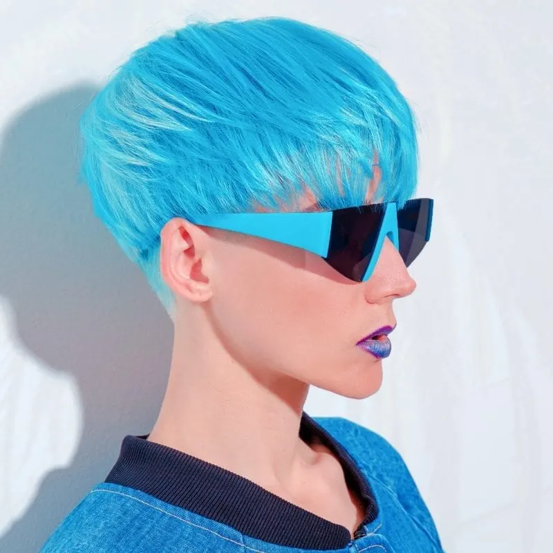 Person with blue hairstyle, blue jean jacket, and blue sunglasses