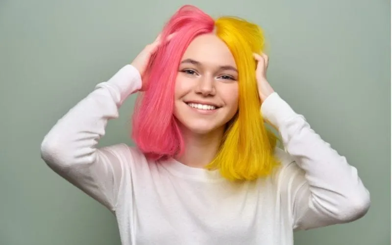 Woman with a half-half e-girl haircut with half yellow and half pink