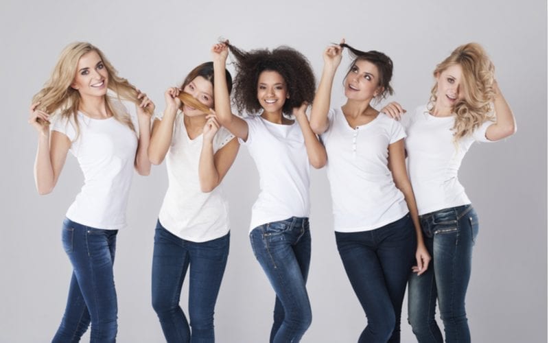 Different hair types on five women standing in a studio against gray background