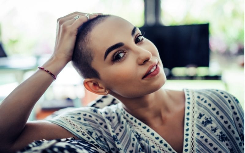 Woman with a shaved head and buzz cut coils