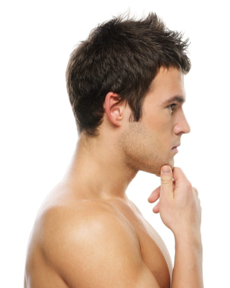 Man standing without a shirt holding his chin and wearing a haircut for guys with big foreheads