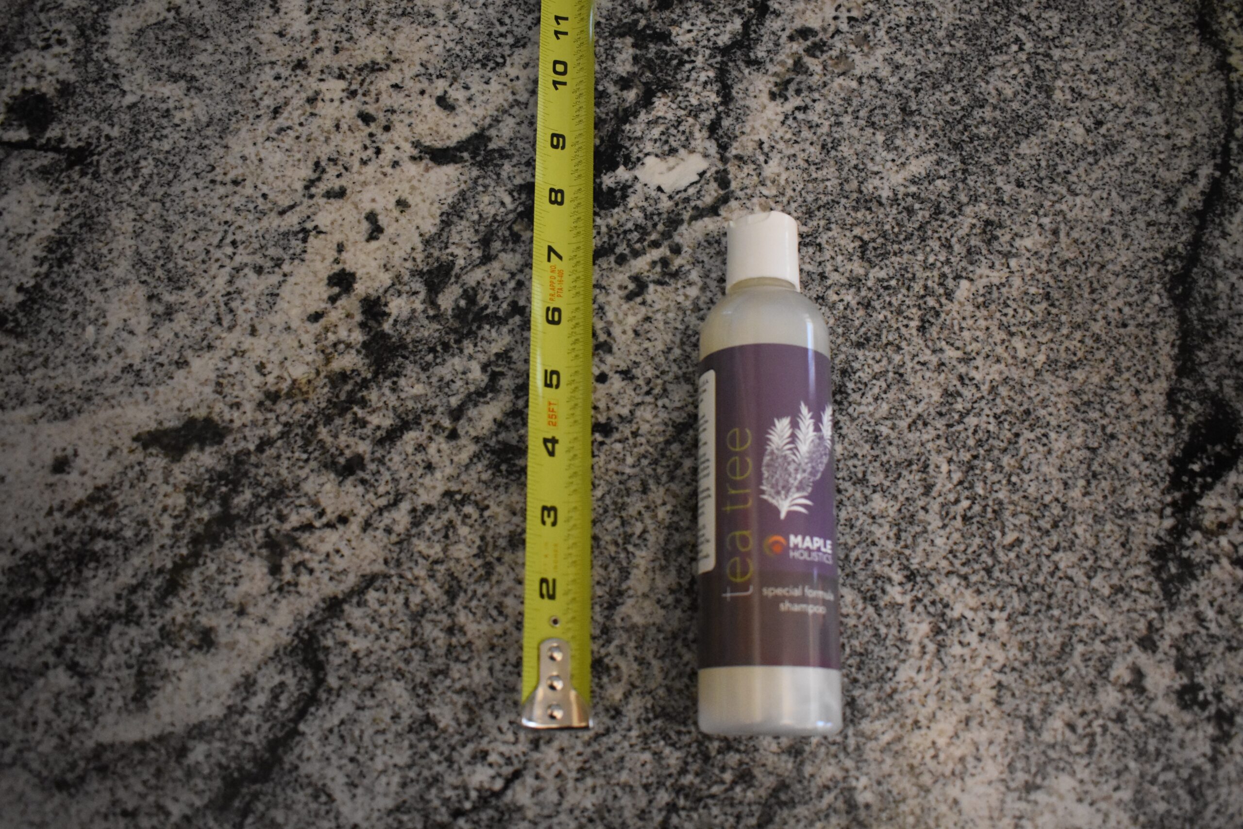 Maple holistics tea tree oil shampoo next to a measuring tape