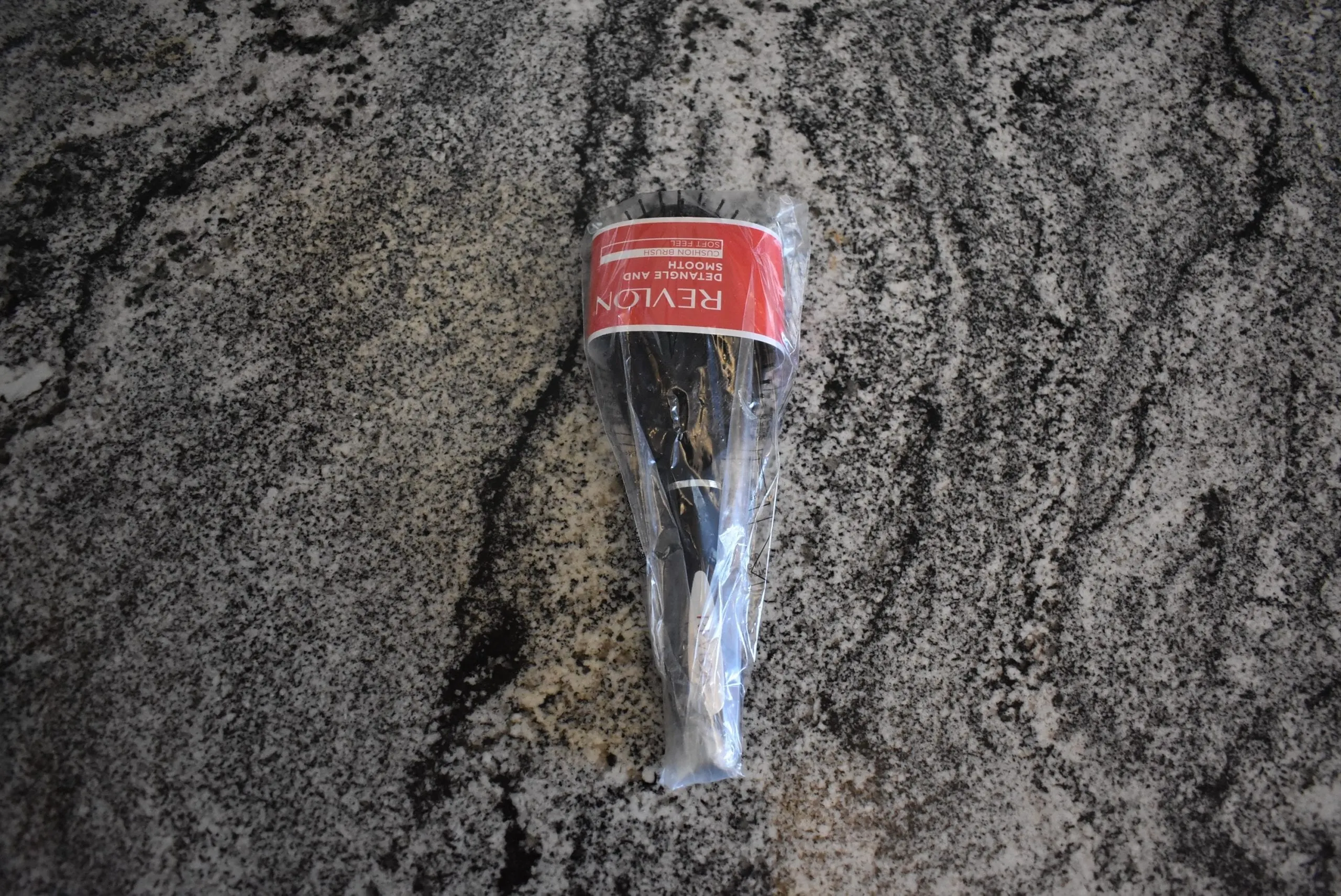 The Revlon Detangled Smooth brush (the best for damaged hair) in plastic wrapping on a counter