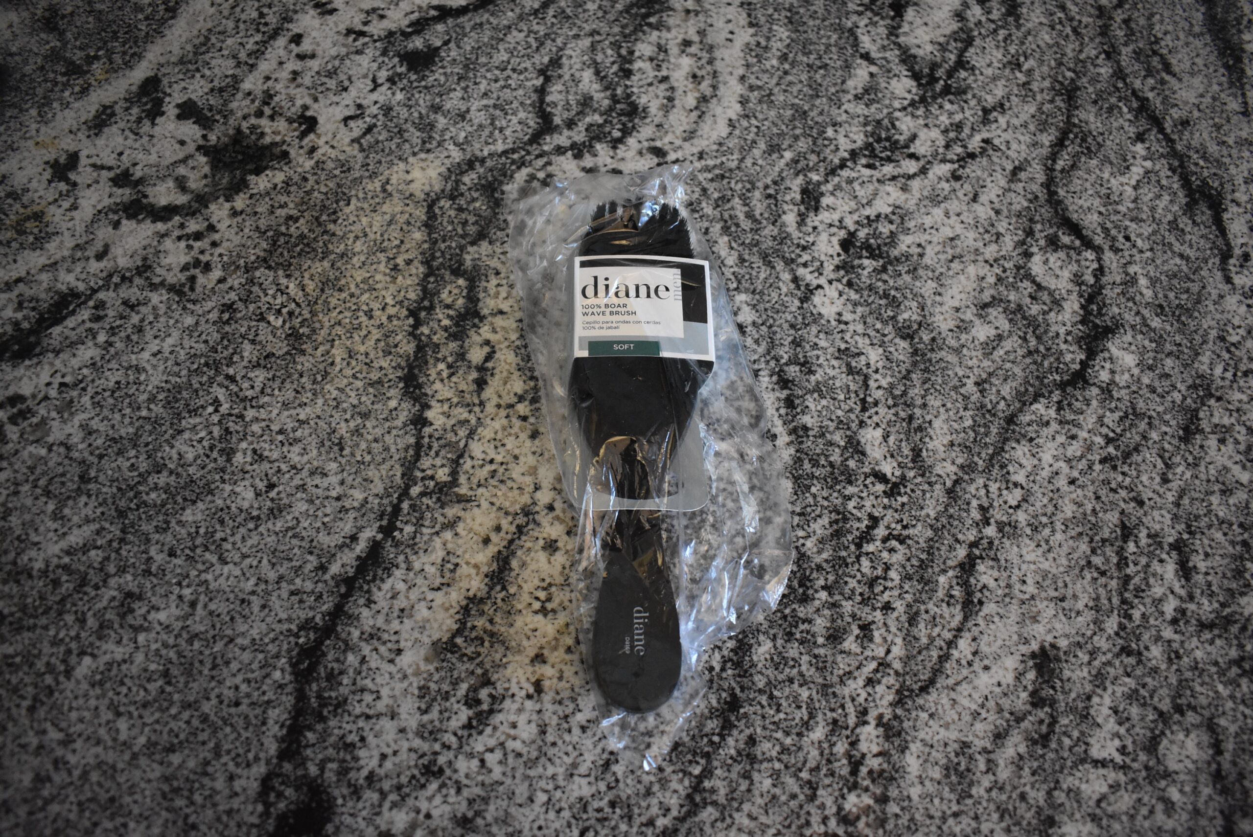 The diane boar bristle hair brush on a counter in its plastic protective sleeve