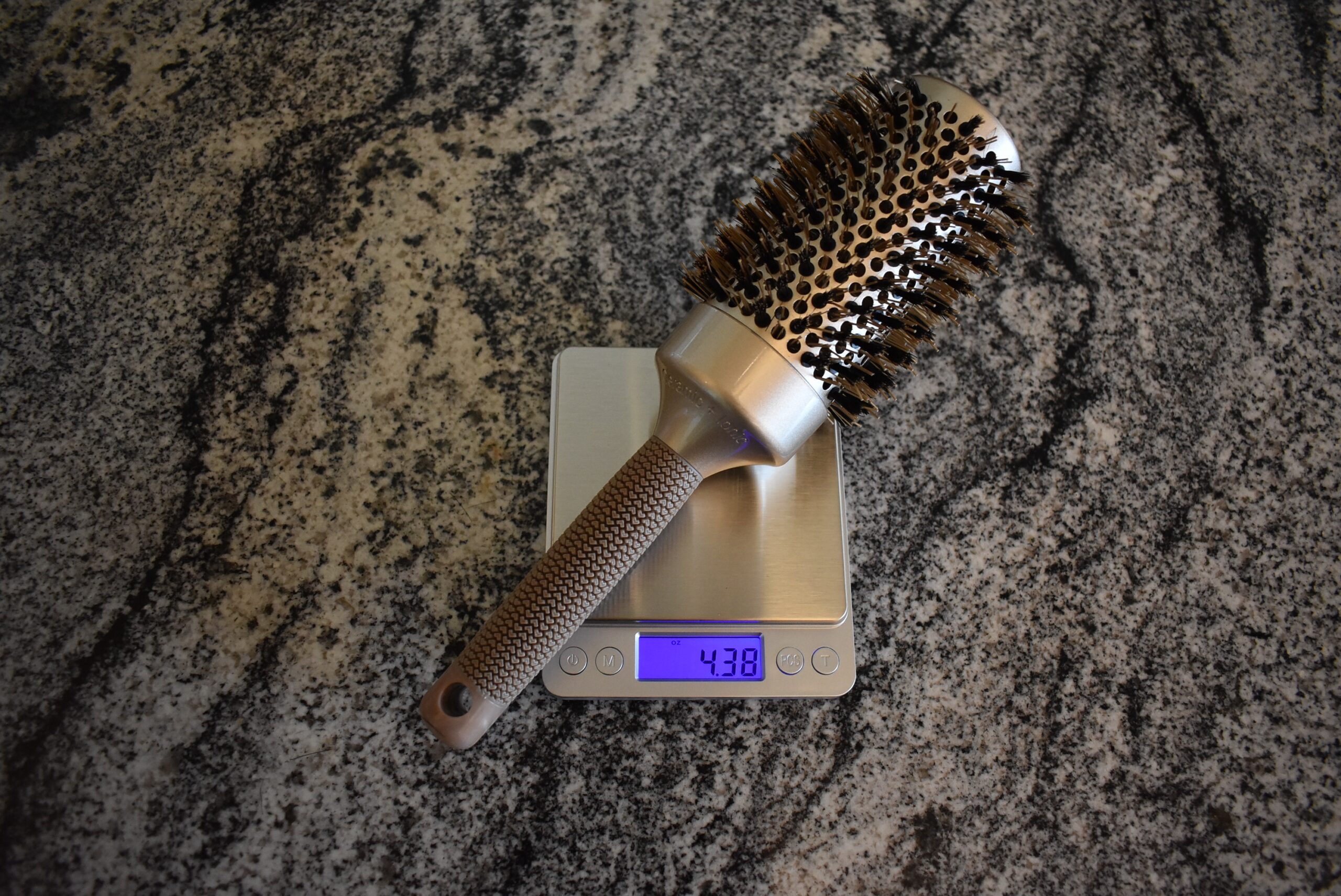 The SUPRENT Nano Thermic Ceramic Round Brush registering 4.38 oz on a kitchen scale