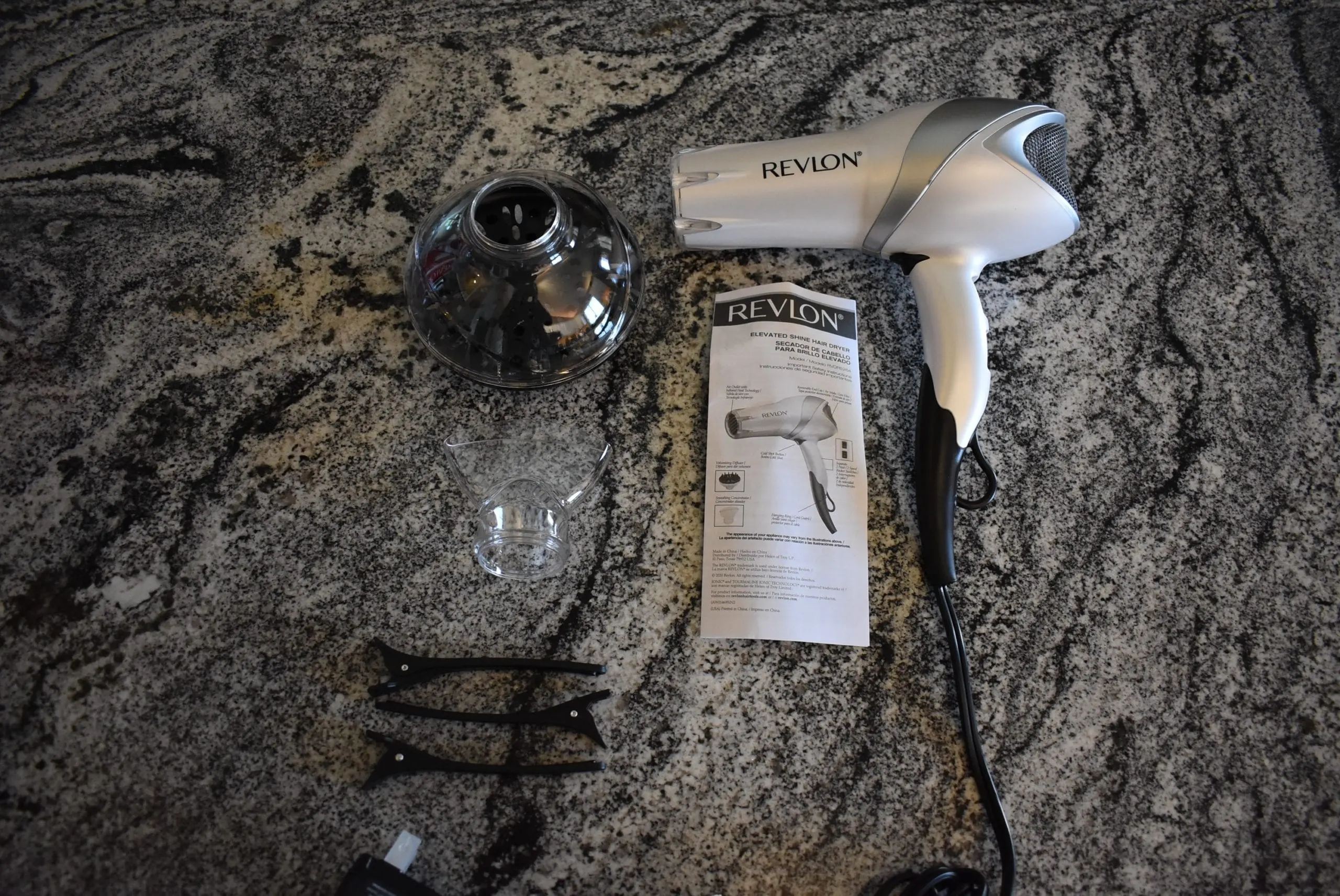 The Revlon hair dryer and its attachments sitting on the granite counter
