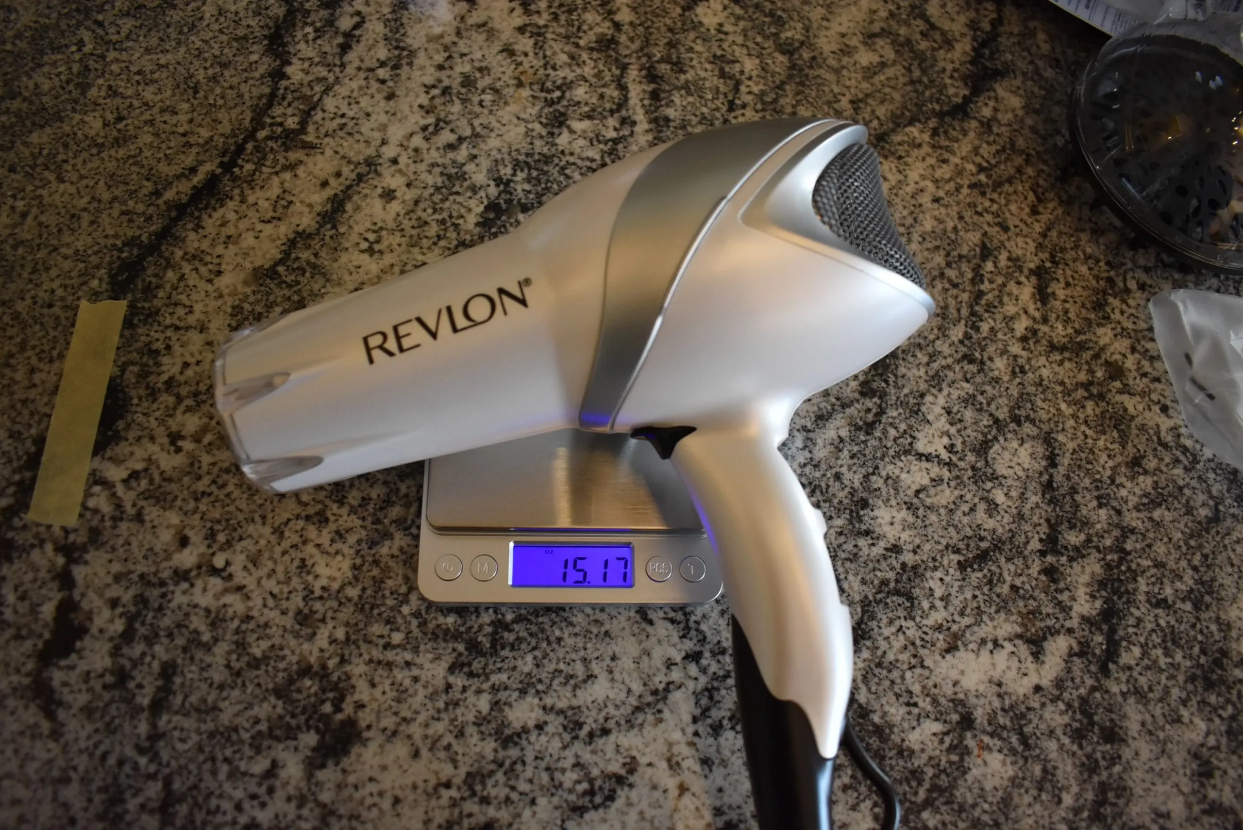The revlon white hair dryer on a scale reading 15.17 oz