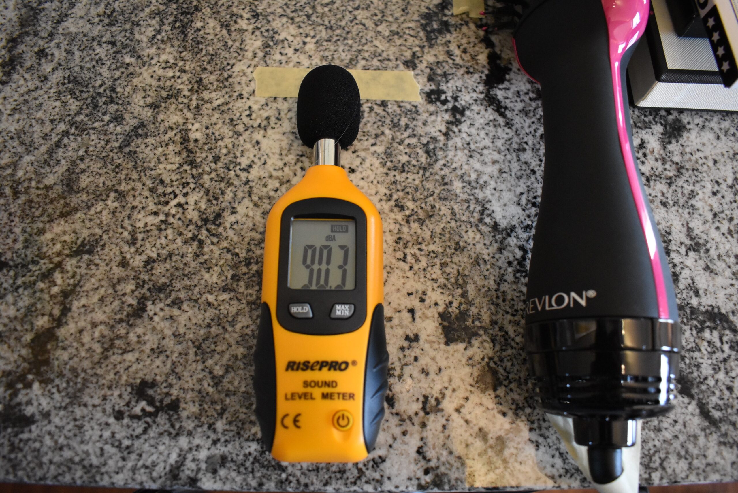A decibel meter registering 90.3 for the Revlon hair dryer brush