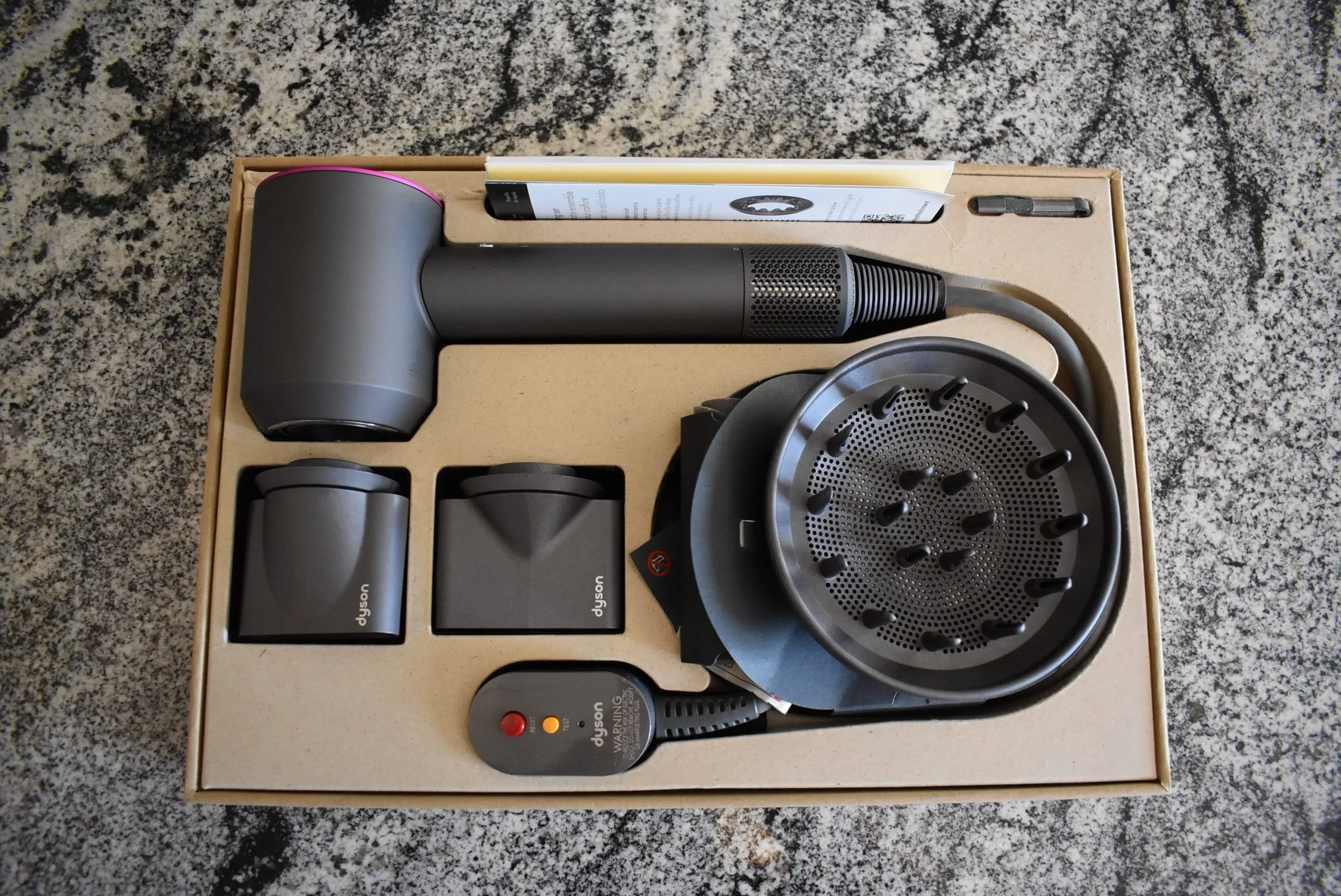 The inside of the dyson supersonic hair dryer box for a product review
