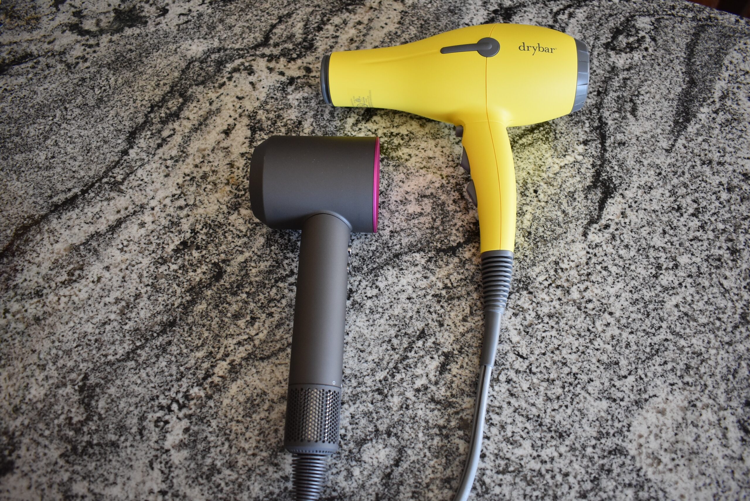 To help answer is the dyson hair dryer worth it, the appliance sits on a counter next to the Drybar buttercup