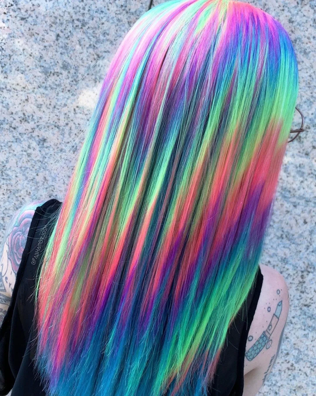 Neon cyberpunk hairstyle that is holographic on a woman in a black tank top