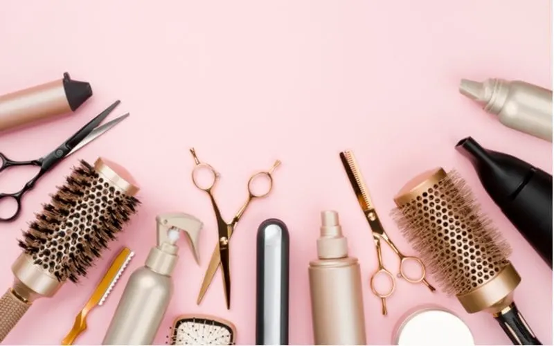 Various hair tools on a pink counter against plain background for a piece on Smartstyle salon pricing