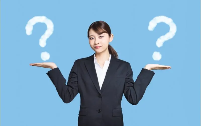 Woman comparing two things with a question mark above each hand on her right and left
