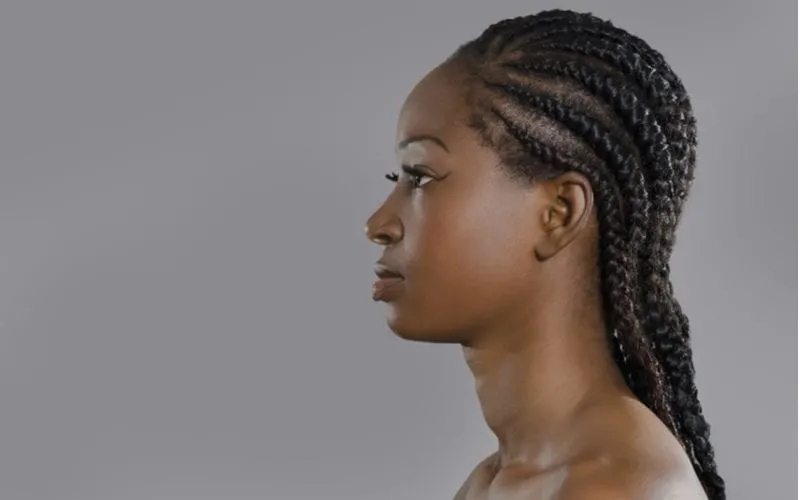 Side profile of a lady with mega swirled cornrows, a natural hair style, in a studio