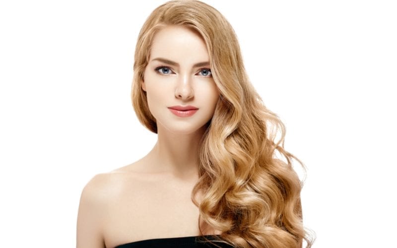 Fair-skinned lady with strawberry blonde hair lets it hang down over her black dress