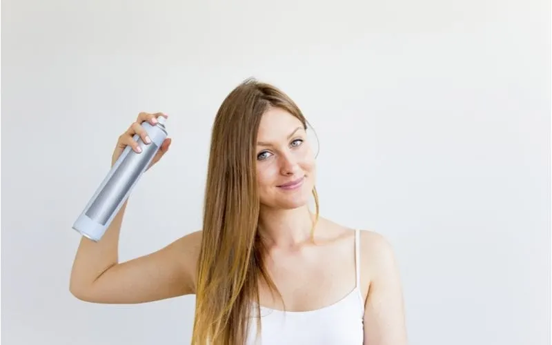 For a piece on how to use dry shampoo, a woman uses this type of hair product while standing in a camisole