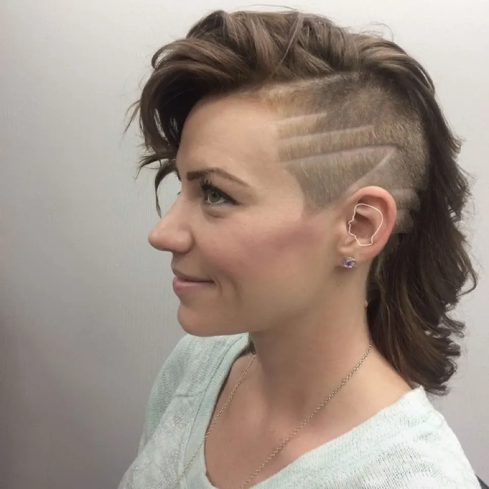 Lady with an extreme faded ash brown haircut grins as she looks ahead (side profile)