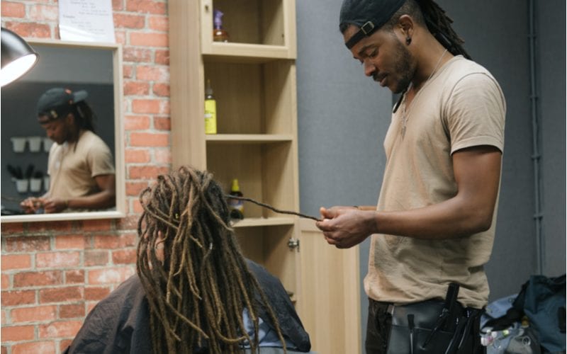 Close up of a man starting dreads for a guy in an African Braiding studio