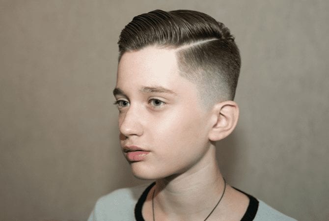 Stylish man with a general type of fade haircut and a hard part (also known as the G Eazy haircut) looks ahead