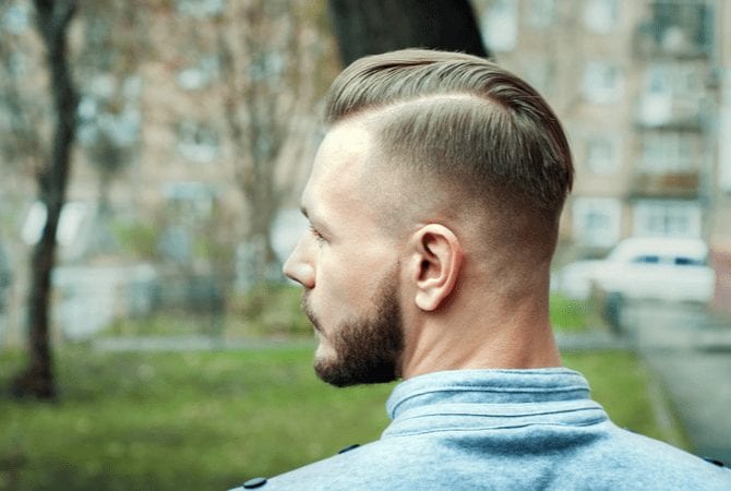 Man with a sporty fade haircut looks to his left from behind for a piece on types of fades