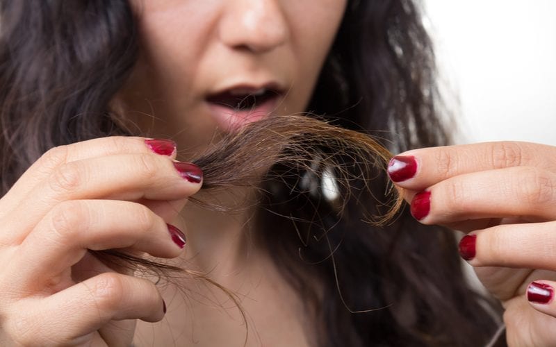 Lady who did not ask "what is hair serum" looks at the split ends of her damaged hair