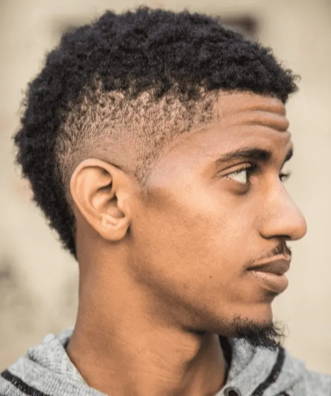 Man with a unique type of fade haircut looks to his right with a goatee