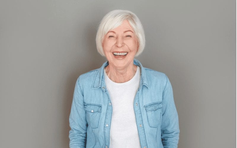 Ear-Length Bob With Side Bangs on a woman in a jean jacket for a style on the best hairstyles for women over 60