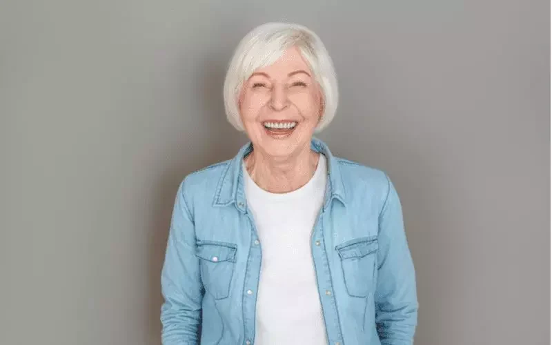 Ear-Length Bob With Side Bangs on a woman in a jean jacket for a style on the best hairstyles for women over 60