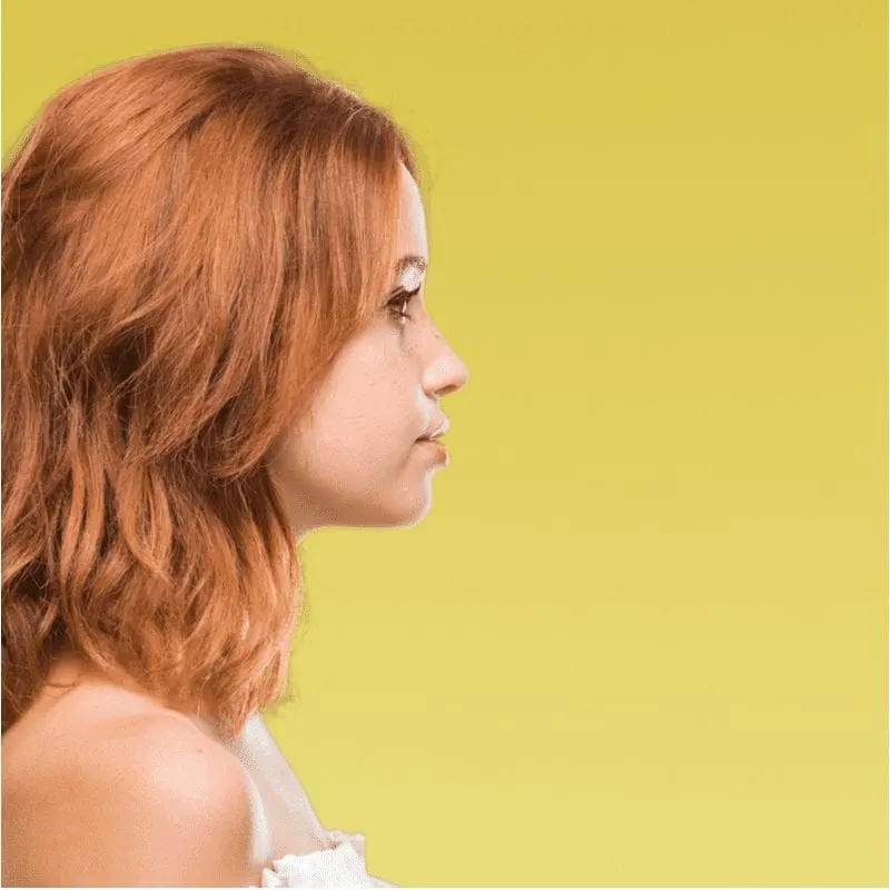 For a piece on what is a lob haircut, a woman with such a style in a side profile pic in a yellow room