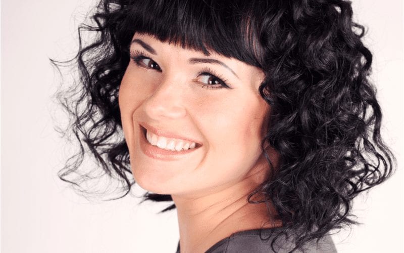 Woman has a Curly Chop With Blunt Bangs haircut